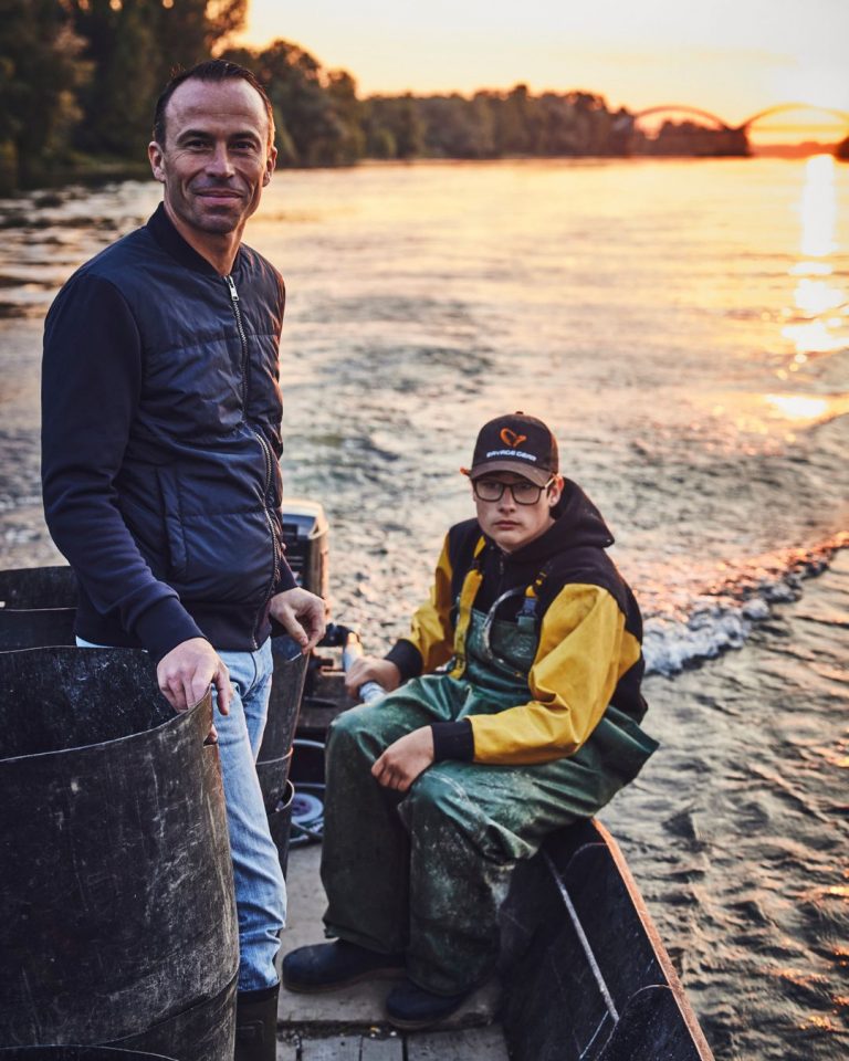 Christophe Hay et un pêcheur sur une barque au coucher du soleil, sur la Loire