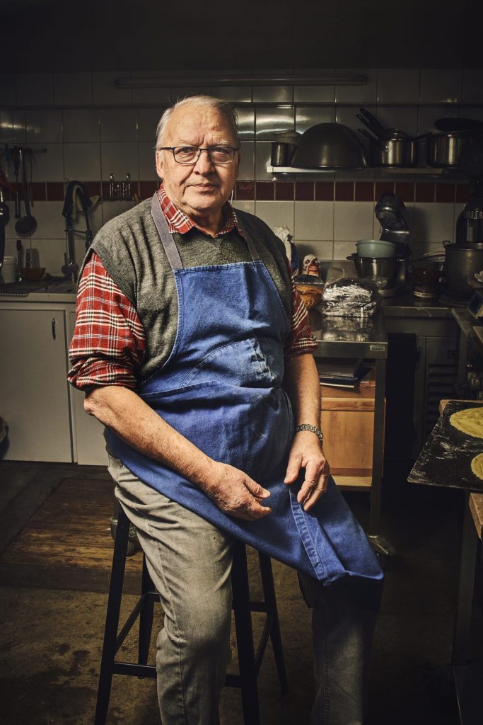 Christian Mécrin en tablier dans sa cuisine